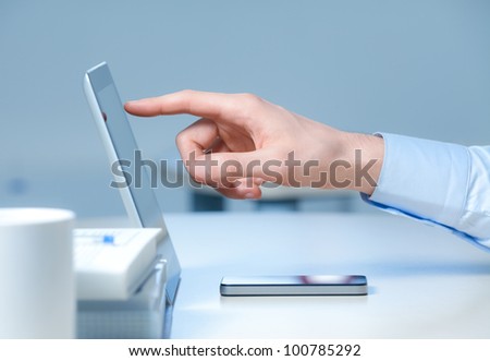 Hand pointing on modern digital tablet pc at the workplace.