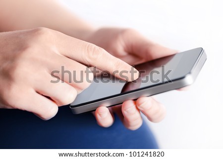 Girl hand touching screen on modern mobile smart phone. Close-up image with shallow depth of field focus on finger.