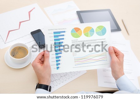 Businessman at the modern workplace analyzing success information on the chart.