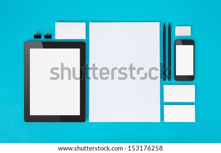 Set Of Variety Blank Office Objects Organized For Company Presentation Or Branding Identity With Blank Modern Devices. Isolated On Blue Paper Background.