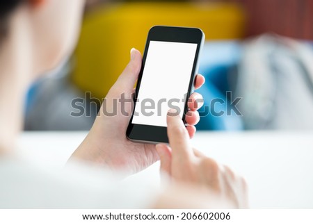 Woman with modern mobile phone in hands touching on a blank screen. Blurred office interior on a background.