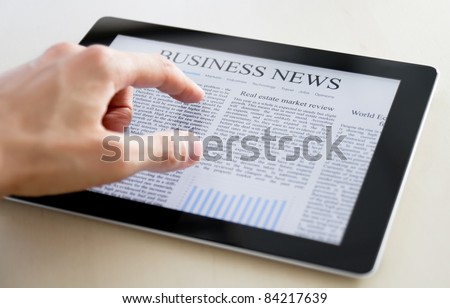 Man hands are pointing on touch screen device with business news. Man hands are pointing on touch screen device with business news.