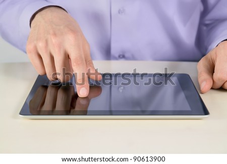 Closeup shot of businessman hands are touching on contemporary generic tablet pc. Shallow depth of field on finger.