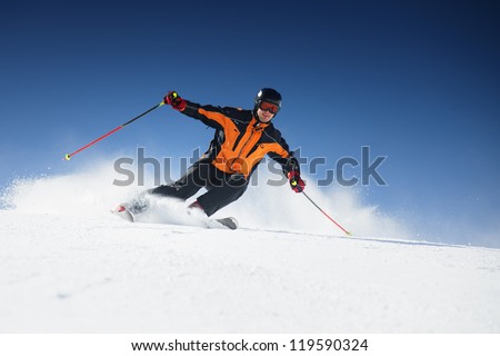 Skier In Mountains, Prepared Piste And Sunny Day