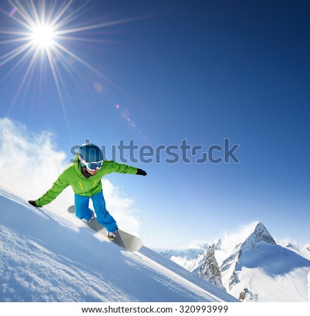 Snowboarder skiing in high mountains.