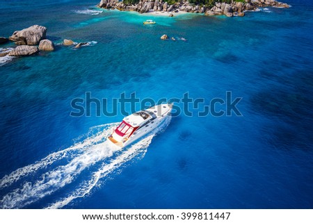 Motor boat in amazing colorful water of Seychelles Coco Island nature