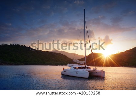 Yacht - Catamaran in the tropical sea at sunset. Yachting theme. Yachting background. Sailing time. Sailboat. Yacht. Luxury yacht.