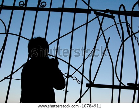 silhouette of a boy near the fence