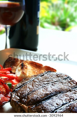 grilled steak and wine at an outdoor setting