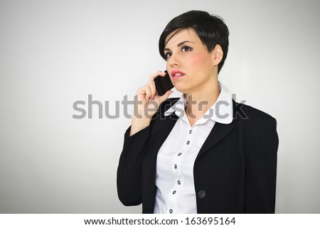 Young business woman talking on the mobile phone receiving bad news. Retro background with vignette effect.