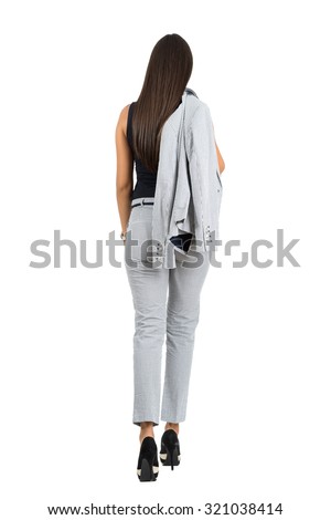 Rear view of business woman in formal wear holding jacket walking away.  Full body length portrait isolated over white studio background.