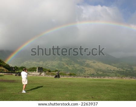 Man photographing a rainbow