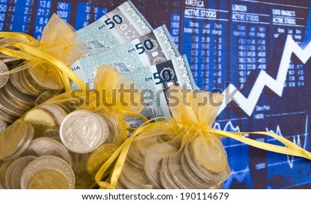 Coins in sheer pouch gold and money on the paper printed financial stock charts  as background.
