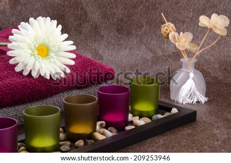 Candle container, towel, flower and aroma therapy flower on the sparkle brown Momento texture background