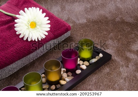 Candle container, towel, flower and aroma therapy flower on the sparkle brown Momento texture background: A concept and idea for interior design