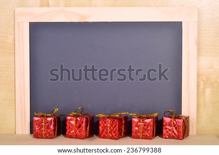 A lined of wrapped gift in front of the blank blackboard