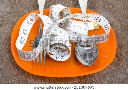 Measurement tape with spoon and fork on the plate