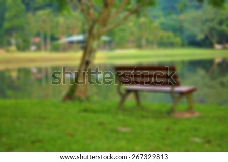 Blurred image for background of empty chair facing the natural green forest and lake