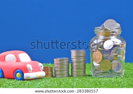 saving concept for buying a car with stacked of coin, coin in the glass jar and car toy