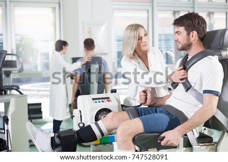physicians with patients in a gym for physical rehabilitation dynamometer in the foreground and in the background cycle ergometer/ gym physiatric rehabilitation
