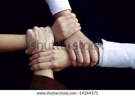 a four people handshake outdoors on black