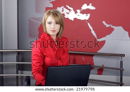 beautiful news TV Presenter in front of the laptop and looking at the camera