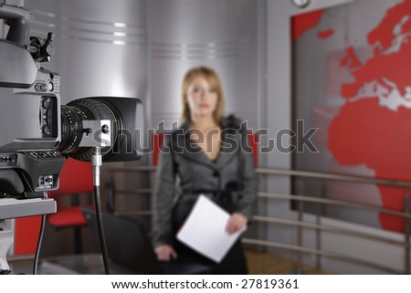 unrecognizable television news reporter in front of the video camera with documents in hand