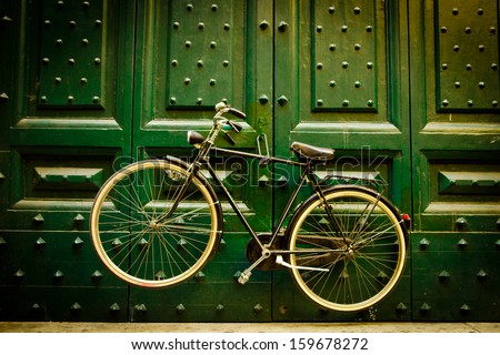 Classic bike hanging on a big green door