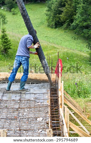 Builder pouring cement on a small construction site