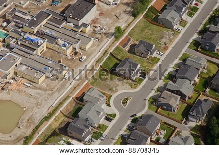 Aerial view of new retail development behind quiet suburban homes