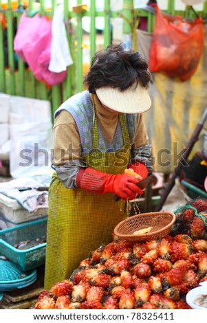 Woman selling sea pineapple and seafood in traditional Korean Wet Market