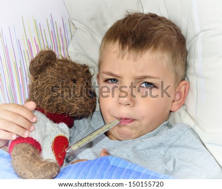 Little sick boy lying in bed with fever