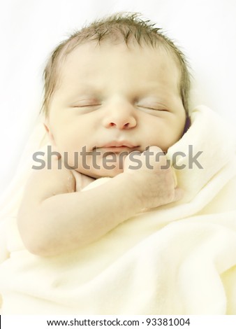 Hi-key portrait of newborn baby in a blanket.