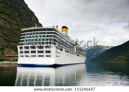 Big luxury cruise liner in the port of Flam reflecting in still clear waters of the fjord, Norway