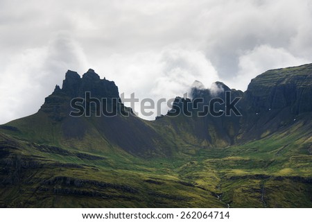 Sharp mountain peaks covered with green moss among clouds, Westfjords, Iceland