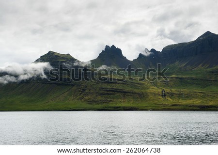 Green and black mountain peaks near the sea in Westfjords, Iceland