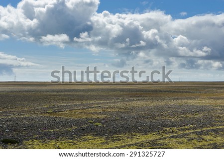 Empty dead land covered with volcanic ashes and fragile vegetation on a sunny summer day, near glacier lagoon Jokulsarlon, South Iceland