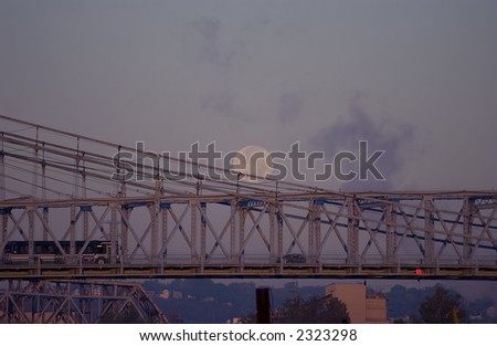 The full moon sets near dawn over the Roebling Bridge in Cincinnati, Ohio.