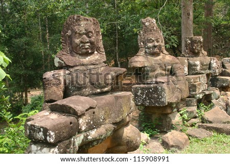 Stone carved deities line a bridge over a river in  Cambodia as guardians to keep evil spirits away
