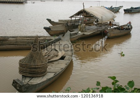 Small homemade fishing boats line a dock at a floating city in Vietnam on the Mekong River