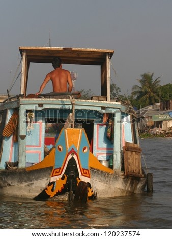 A fisherman drives his colorfully painted boat on the Mekong River in Vietnam