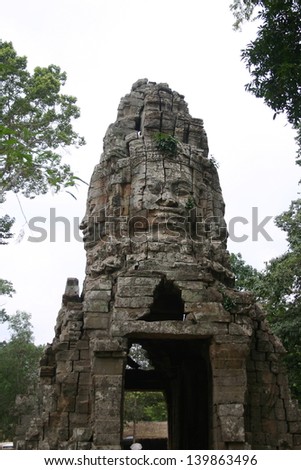 Stone faces guard the temple entrance to Angkor Thom in the jungle complex of Angkor, Cambodia