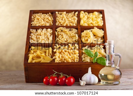 Assorted pasta mix in wooden box and seasoning ingredients
