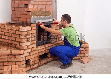 Worker building a masonry heater in a new home - copy space