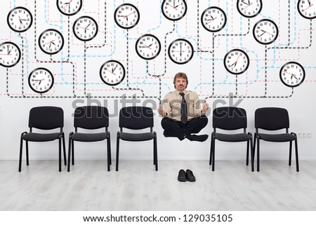 Expert time management - businessman controlling lots of wall clocks