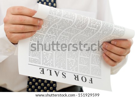 Businessman reading sales ads - closeup on hands and fake text paper