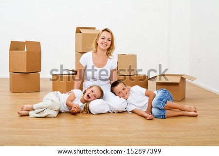 Family moving into a new house - having fun among scattered cardboard boxes
