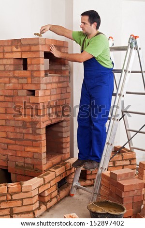 Worker building masonry heater - finishing the fire box