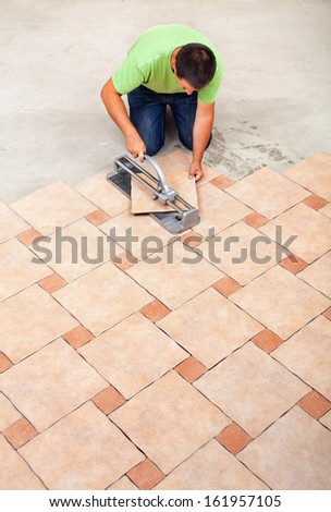 Man laying ceramic floor tiles - top view with copy space
