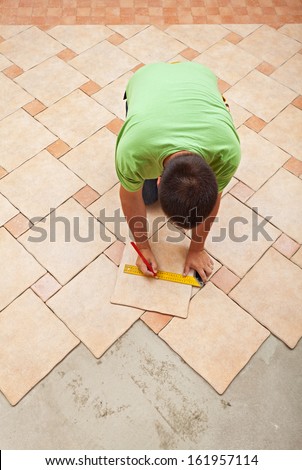 Man laying ceramic floor tiles - top view with copy space